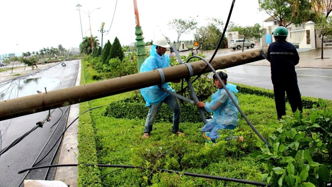 Công nhân điện lực đang sửa chữa cột điện đổ ở tỉnh Phú Yên, miền trung Việt Nam, hôm 4/11, sau khi Damrey tràn qua. 