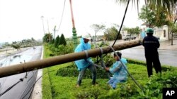 Workers repair a fallen electricity pole in the central province of Phu Yen, Vietnam, Nov. 4, 2017. Typhoon Damrey slammed the south-central coast of Vietnam on Saturday.