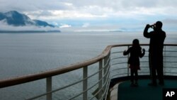 FILE - In this July 28, 2014, photo, a cruise ship passenger takes photos of Alaska's Inside Passage. The decision by the Canadian government to remove mandatory COVID-19 testing for those entering the country comes just in time for the start of the peak season for Alaska cruise ships.