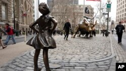 Patung 'Fearless Girl' menghadap ke arah banteng Wall Street di New York (foto: dok). 