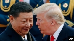 FILE - U.S. President Donald Trump, right, chats with Chinese President Xi Jinping, on Aug. 31, 2019, in Beijing. 