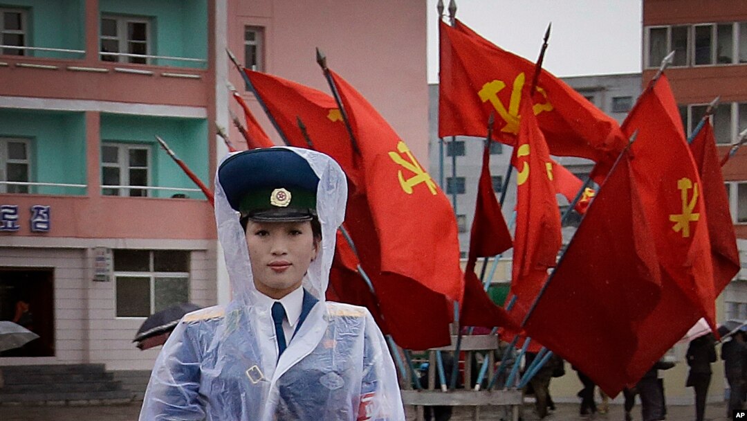 Seorang polisi perempuan Korea Utara mengatur lalu lintas di persimpangan jalan kota Pyongyang, yang di sekitarnya dipenuhi oleh dekorasi bendera partai yang berkuasa di negara itu (5/5). 
