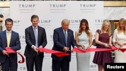 Donald Trump beserta istri dan anak-anaknya menggunting pita dalam peresmian Trump International Hotel di Washington, DC (26/10). (Reuters/Gary Cameron)