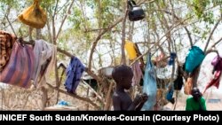 A young boy stands in front of the tree in a camp for the displaced in Mingkamen, where he and his family fled as violence raked the town of Bor in Jonglei state.