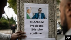 FILE — Demonstrators gather in front of the Embassy of Niger in Paris, in support of Nigerien President Mohamed Bazoum and ECOWAS, Aug. 5, 2023. 