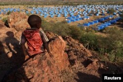 FILE— A boy sits atop a hill overlooking a refugee camp near the Chad-Sudan border, November 9, 2023.