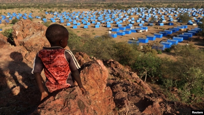 FILE - A boy sits atop a hill overlooking a refugee camp near the Chad-Sudan border on Nov. 9, 2023. A U.N. report released March 1, 2024, says the ongoing conflict in Sudan has resulted in the displacement of 8.1 million people.