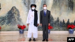 FILE - Chinese State Councilor and Foreign Minister Wang Yi, right, meets with Mullah Abdul Ghani Baradar, political chief of Afghanistan's Taliban, in Tianjin, July 28, 2021. (Photo released by China's Xinhua News Agency)