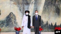 Chinese State Councilor and Foreign Minister Wang Yi, right, meeting with Mullah Abdul Ghani Baradar, political chief of Afghanistan's Taliban, in Tianjin, in this photo taken on July 28, 2021, and released by China's Xinhua News Agency.
