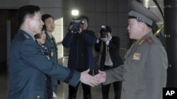 South Korean Colonel Moon Sang-gyun (L) shakes hands with his North Korean counterpart Ri Son-kwon before their talks at the south side of the truce village of Panmunjom in Paju, north of Seoul, February 9, 2011