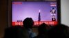 People watch a TV broadcasting file footage of a news report on North Korea firing a ballistic missile off its east coast, in Seoul, South Korea, October 19, 2021. 