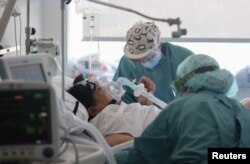 El personal del hospital atiende a un paciente que padece la enfermedad Covit-19 en el hospital del Maril, que abrió una sala adicional el 15 de julio de 2021 en Barcelona, ​​España, para hacer frente a un aumento en el número de pacientes con el virus de la corona.