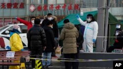 지난 27일 중국 베이징 거리에 설치된 신종 코로바이서 임시검사소에 시민들이 검사를 받기 위해 줄 서 있다. 