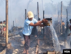 A Rohingya refugee tries to douse a fire at the Cox’s Bazar camp, Dec. 24, 2024. (Md. Jamal for VOA)