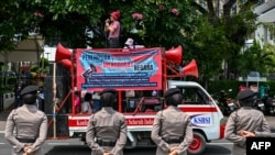 Policewomen keep watch as activists take part in a street protest on the International Day for the Elimination of Violence Against Women, in Jakarta November 25, 2024. 