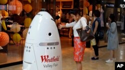 ARSIP – Sophie Li, asal Cupertino, California mengajak robot K5 yang diproduksi Knightscope, Inc. berdansa di pusat perbelanjaan Westfield Valley Fair di San Jose, California (foto: AP Photo/Ben Margot)