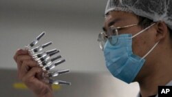 Un empleado inspecciona jeringas de la vacuna producida por SinoVac, en su fábrica en Beijing, el pasado 24 de septiembre.