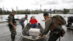 Miembros de equipos de rescate ayudan a las personas a evacuarse tras los estragos del huracán Ida en Luisiana el 30 de agosto de 2021.