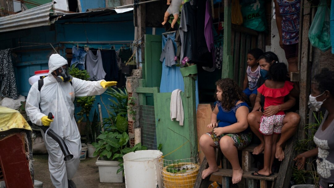 Seorang pekerja bersiap menyemprotkan cairan disinfektan di pemukiman kumuh di Santa Marta, Rio de Janeiro, Brazil, 10 April 2020.