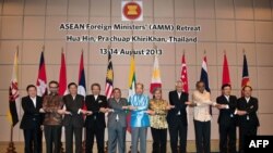 Para Menlu negara-negara ASEAN dan Sekjen Le Luong Minh bergandengan tangan saat berpose bersama dalam pertemuan para Menlu ASEAN di Hua Hin, Thailand (14/8).