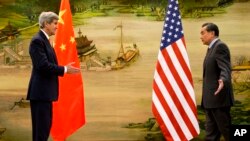 U.S. Secretary of State John Kerry, left, and Chinese Foreign Minister Wang Yi approach to shake hands after attending a news conference at the Ministry of Foreign Affairs in Beijing, Jan. 27, 2016.