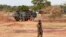 Un soldat burkinabé passe devant un véhicule blindé de transport de troupes français faisant partie d'un convoi militaire français en direction du Niger, arrêté par des manifestants à Kaya, Burkina Faso, le 20 novembre 2021.
