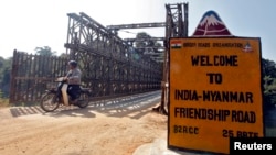 Seorang pria mengendarai kendaraan bermotor roda dua melintasi jembatan perbatasan Indo-Myanmar di kota perbatasan Moreh, di negara bagian Manipur, India timur laut, 25 Januari 2012. (Foto: Reuters)