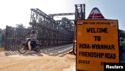 A man rides his motorised two-wheeler across the Indo-Myanmar border bridge at the border town of Moreh, in the northeastern Indian state of Manipur, January 25, 2012. A flurry of high-level official visits shows both countries are keen to get the chemist