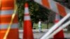 A child rides a scooter past barricades at an entrance to Tower Grove Park in St. Louis, Missouri, March 31, 2020.