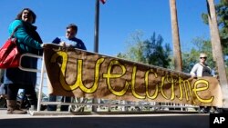 FILE - A sign welcoming Syrian refugees is placed at the entrance to the office of the Arizona governor during a rally at the Arizona Capitol in Phoenix, Nov. 17, 2015. A majority of New York voters are opposed to allowing Syrian refugees, a new poll shows.