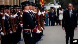 Regional Catalan President Quim Torra (Rr) walks next to the Catalan regional police 'Mossos D'Esquadra' honor guards the day ahead of the Catalan National Day in Barcelona, Spain, Sept. 10, 2018.