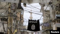 An Islamic State flag hangs amid electric wires over a street in Ain al-Hilweh Palestinian refugee camp, near the port city of Sidon, southern Lebanon, Jan. 19, 2016. 