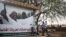 Sudanese boys walk past an election campaign banner in support of President Omar al-Bashir that reads "community commission in support of nominating Marshal Omar al-Bashir, in Khartoum, Sudan, April 11, 2015. 