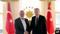 Turkey's President Recep Tayyip Erdogan, right, shakes hands with Hamas movement chief Ismail Haniyeh, prior to their meeting in Istanbul, Feb. 1, 2020. 