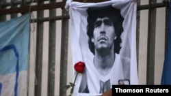 Una rosa es colocada junto a una imagen de Diego Maradona, en el Obelisco de Buenos Aires, al reunirse los fanáticos para lamentar su muerte.