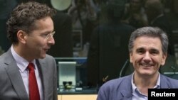 Menteri Keuangan Yunani yang baru dipilih, Euclid Tsakalotos (kanan) disambut Presiden Eurogroup Jeroen Dijsselbloem di Brussels, Belgia (7/7). (Reuters/Yves Herman)