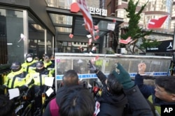 9일 한국노총 회원들이 여의도 국민의힘 당사를 향해 윤석열 한국 대통령 탄핵안에 투표하지 않은 여당 의원들의 이름이 적힌 종이를 찢어 던지고 있다.