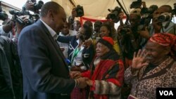 Rais wa Kenya Uhuru Kenyatta akisalimiana na mpiga kura mkongwe muda mfupi kabla ya kupiga kura katika eneo la Gatundu South, Kaunti ya Kiambu siku ya Alhamisi.