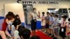 FILE - Flight attendants from Taiwan's China Airlines stage a 'flight to nowhere' event for children, at the China Airlines' campus in Taoyuan City, Taiwan, Aug. 8, 2020.