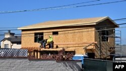 Los trabajadores trabajan en el exterior de una nueva casa que se está construyendo en Alhambra, California, el 21 de agosto de 2024. AFP