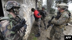 FILE - Soldiers of the Special Purpose Marine Air-Ground Task Force (SPMAGTF) and soldiers of the French 21st Marine Infantry Regiment arrest the acting terrorist "Geronimo" as they take part in a Franco-American military exercise called "Garrigues Fury 2014" at military camp of Garrigues, near Nimes, southern France, Feb. 13, 2014. 