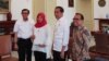 Baiq Nuril, disaksikan oleh Presiden Joko Widodo menerima salinan amnesti dari Menkumham Yasonna Laoly, di Istana Kepresidenan Bogor, Bogor, Jumat, 2 Agustus 2019. (Foto: VOA/Ghita)