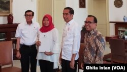 Baiq Nuril, disaksikan oleh Presiden Joko Widodo menerima salinan amnesti dari Menkumham Yasonna Laoly, di Istana Kepresidenan Bogor, Bogor, Jumat, 2 Agustus 2019. (Foto: VOA/Ghita)