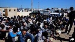 African illegal migrants wait to receive medial assistance after being rescued by coastal guards at a port in Tripoli, Libya, April 11, 2016.