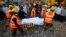 Rescue workers use a stretcher to carry the body of a victim across the rubble after the collapse of a residential building in Thane district, on the outskirts of Mumbai, April 6, 2013. 