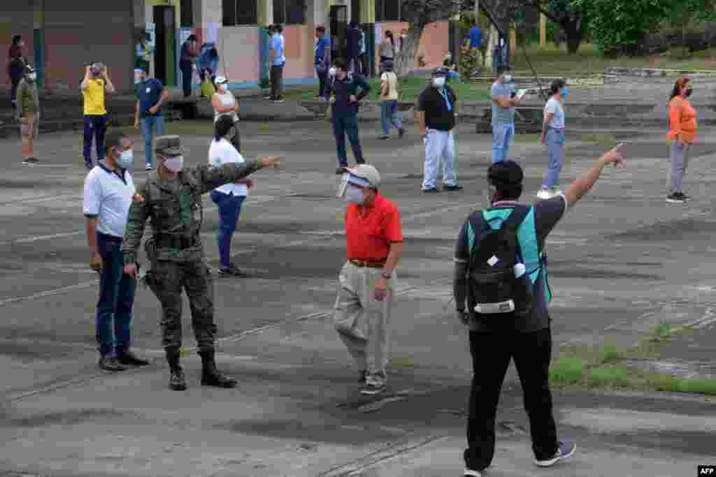 Un miembro del Ej&#233;rcito ecuatoriano pide a la ciudadan&#237;a respetar el distanciamiento social en la escuela Hugo Ortiz, durante las elecciones generales, en Guayaquil, Ecuador, el 7 de febrero de 2021.