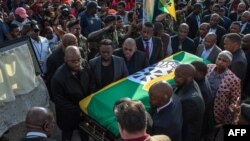 Quelques personnes portent le cercueil de Winnie Madikizela-Mandela recouvert d'un drapeau de l'ANC à Soweto, Johannesburg, le 13 avril 2018.