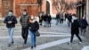 Orang-orang mengenakan masker berjalan-jalan di alun-alun Kota Codogno, Italia, satu tahun setelah kota itu menjadi pusat wabah pandemi COVID-19 di Eropa, 11 Februari 2021. (Foto: Flavio Lo Scalzo/Reuters)