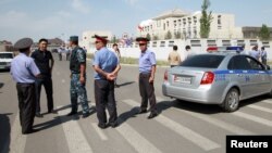 Investigators, Interior Ministry officers and members of security forces gather near the site of a bomb blast outside China's embassy in Bishkek, Kyrgyzstan, August 30, 2016.