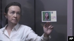La periodista ruso-estadounidense de Radio Free Europe/Radio Liberty Alsu Kurmasheva sostiene una tarjeta que dice en idioma ruso: "La esperan en casa", mientras asiste a una audiencia judicial en Kazán, Rusia, el 1 de abril de 2024.